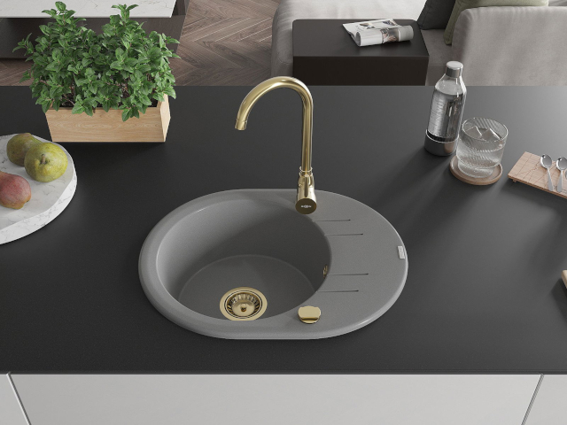 Goudkleurige gootsteen met gouden kraan en sifon