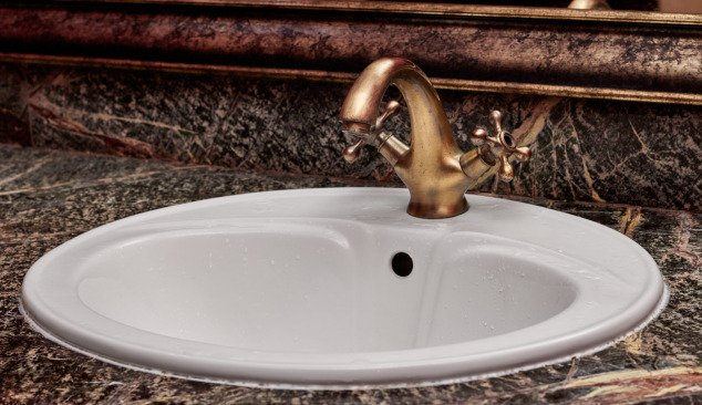 Gouden en koperen kranen in de badkamer