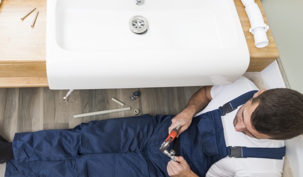 Op welke hoogte moet de afvoer voor een wastafel volgens de loodgietersnorm worden geplaatst?