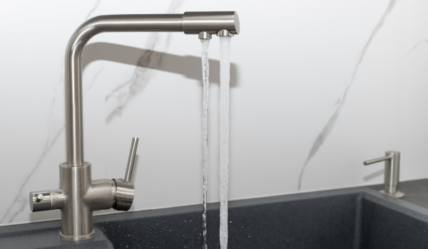 Hoe pas je een dispenser aan de gootsteen aan?